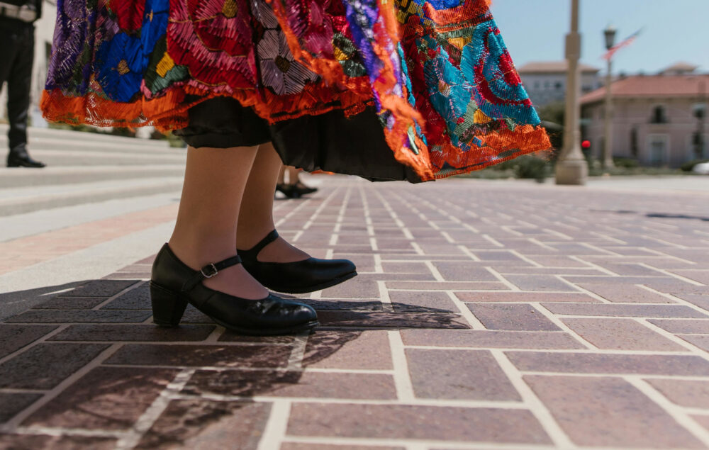 una falda de colores de estilo folclórico con zapatos negros sobre un suelo de baldosas