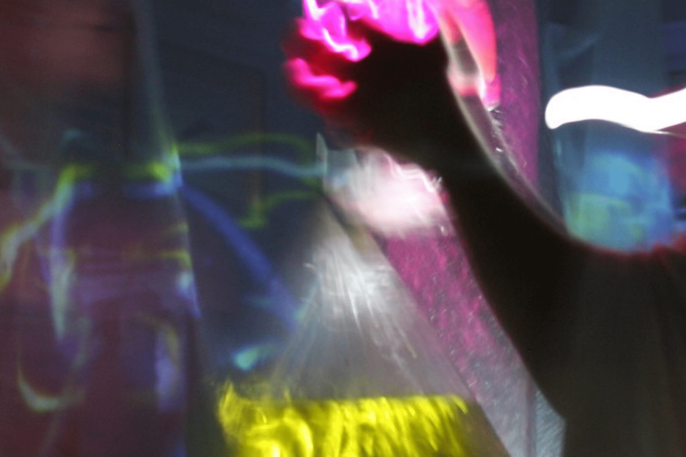 Imagen abstracta de un braco con luces de neón rosas y fondeo amarillo y azul